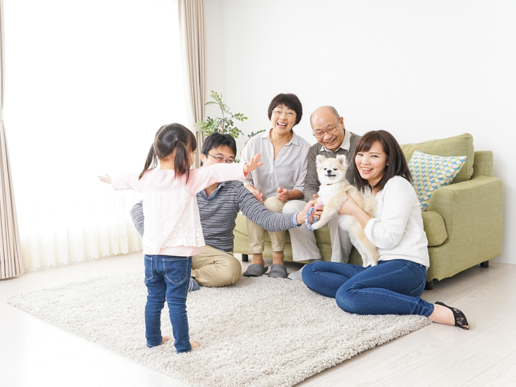 Three-generation family playing with dog