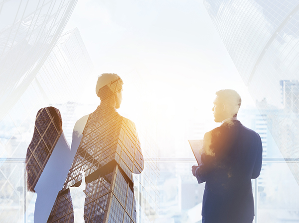 Abstract business concept with three silhouettes of businessmen double exposed on modern skyscrapers backdrop.