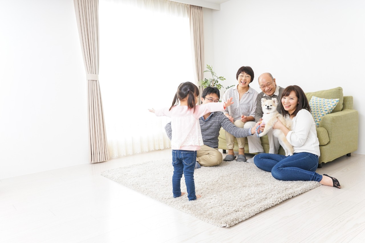 Three-generation family playing with dog